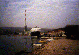 A hajó és a háttérben a plomini új erőmű